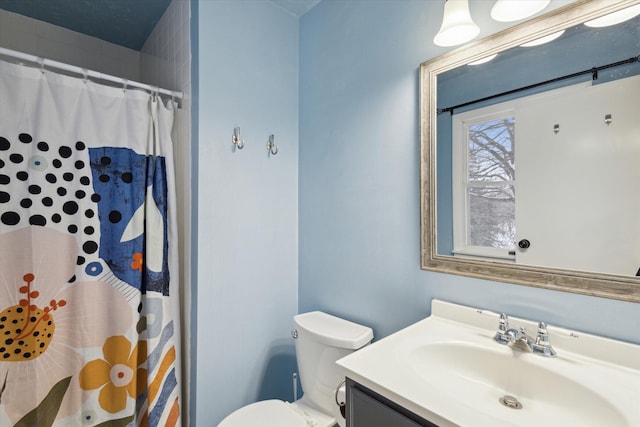 bathroom with curtained shower, vanity, and toilet