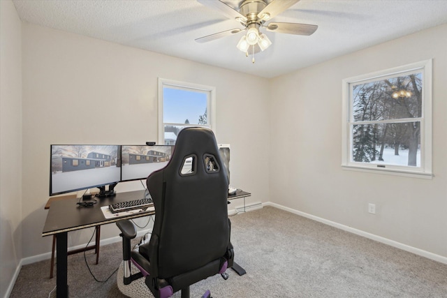 carpeted home office with ceiling fan and a textured ceiling