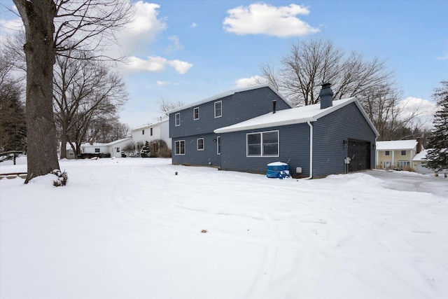 snow covered house with a garage