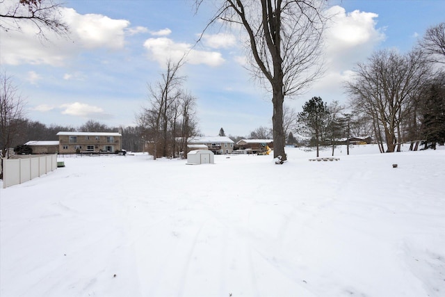 snowy yard with a storage shed