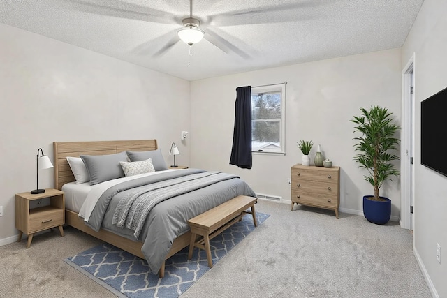 bedroom with ceiling fan, a baseboard radiator, light carpet, and a textured ceiling