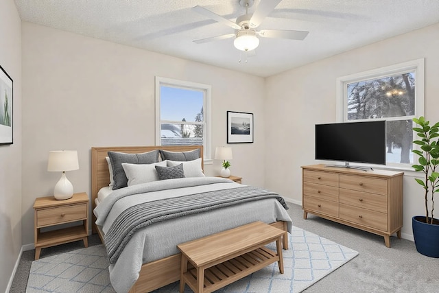 bedroom featuring light carpet, ceiling fan, and a textured ceiling