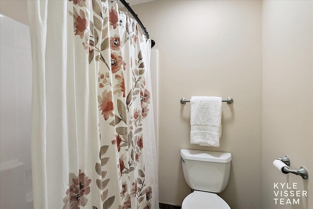 bathroom with toilet and a shower with curtain