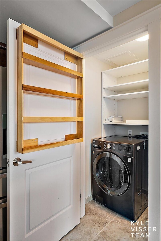 washroom with washer / dryer and light tile patterned flooring