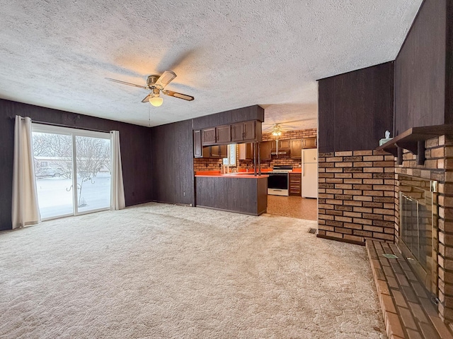 unfurnished living room featuring a fireplace, light carpet, and ceiling fan