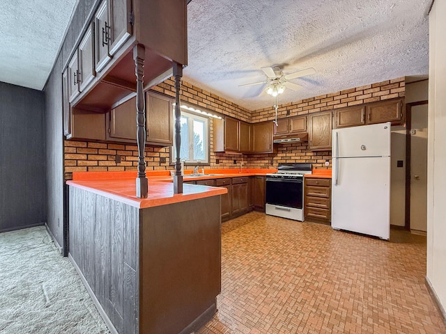 kitchen with kitchen peninsula, a textured ceiling, white appliances, and ceiling fan