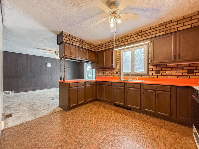 kitchen featuring ceiling fan, sink, and a textured ceiling