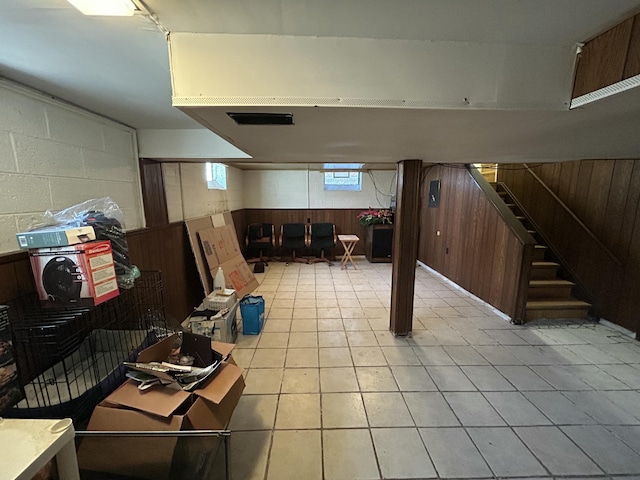 basement with light tile patterned floors and wooden walls