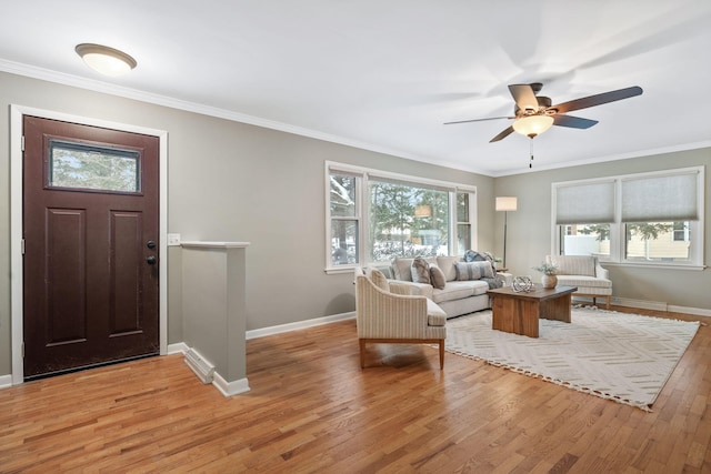 foyer featuring ceiling fan, a wealth of natural light, crown molding, and light hardwood / wood-style flooring