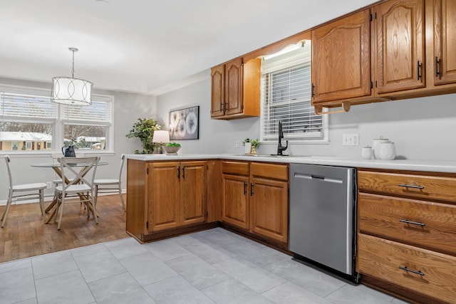 kitchen featuring decorative light fixtures, dishwasher, sink, light tile patterned floors, and a chandelier