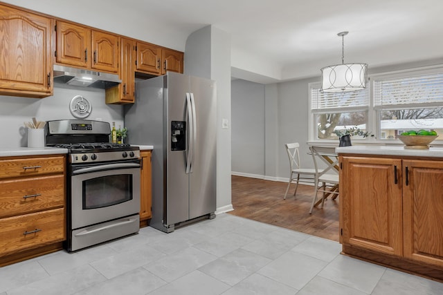 kitchen with a chandelier, light hardwood / wood-style floors, stainless steel appliances, and pendant lighting