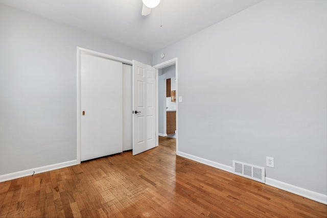 unfurnished bedroom featuring ceiling fan, wood-type flooring, and a closet