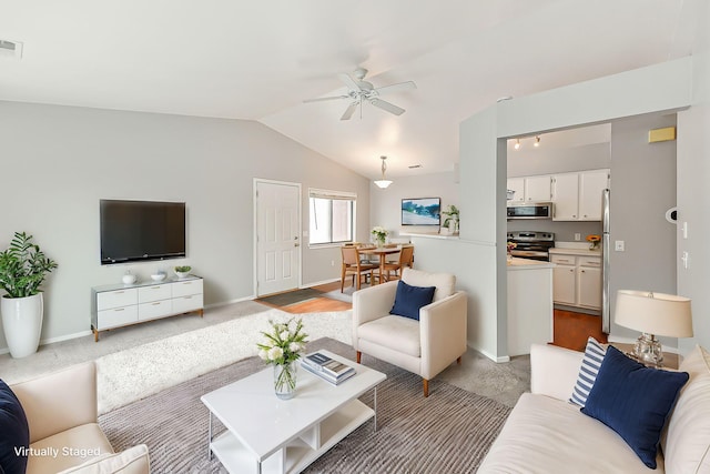 living room featuring ceiling fan, vaulted ceiling, and light carpet