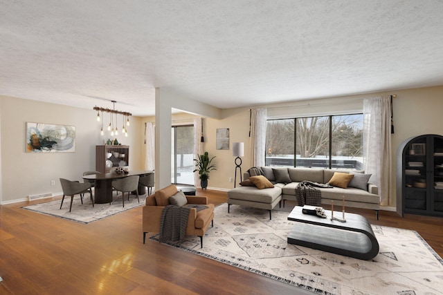 living room featuring a textured ceiling and light hardwood / wood-style flooring