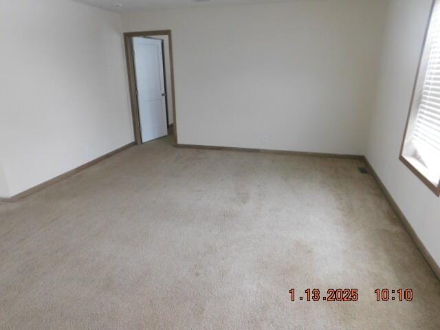 unfurnished room featuring light carpet