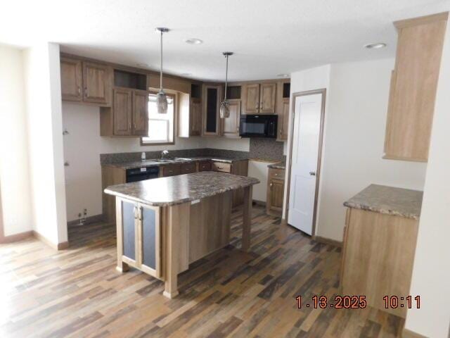 kitchen featuring decorative light fixtures, a kitchen island, dark hardwood / wood-style flooring, and sink