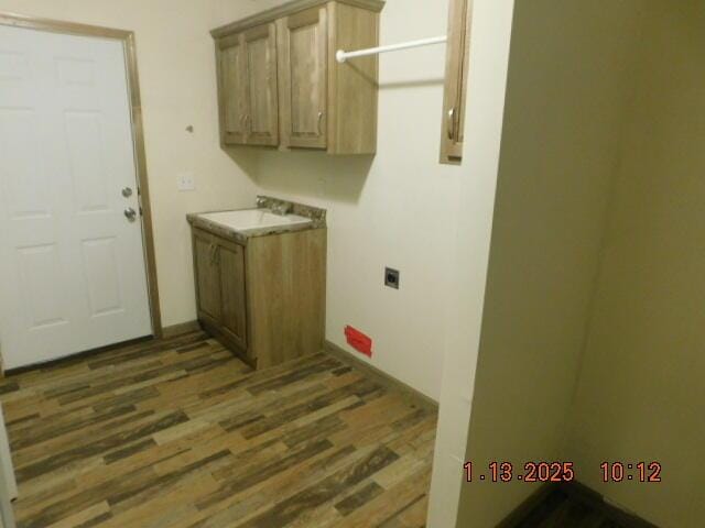 laundry room featuring cabinets, dark wood-type flooring, hookup for an electric dryer, and sink