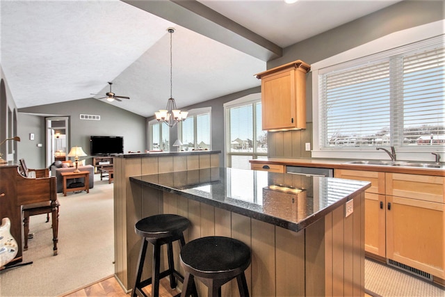 kitchen featuring sink, a kitchen breakfast bar, vaulted ceiling, and light carpet