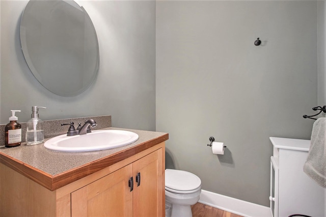 bathroom featuring toilet, vanity, and hardwood / wood-style flooring