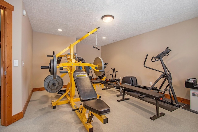 exercise room with a textured ceiling and light carpet