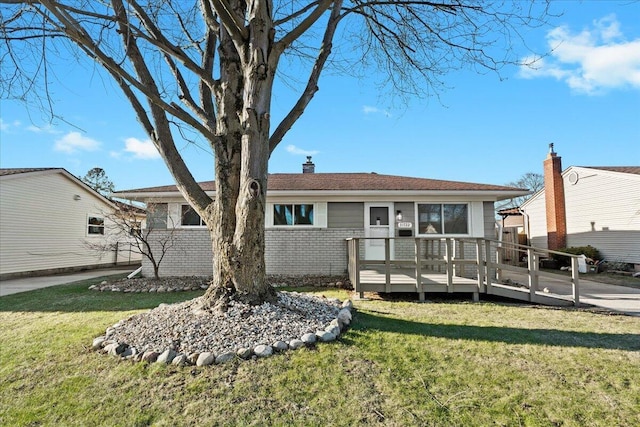 rear view of property with a deck and a lawn