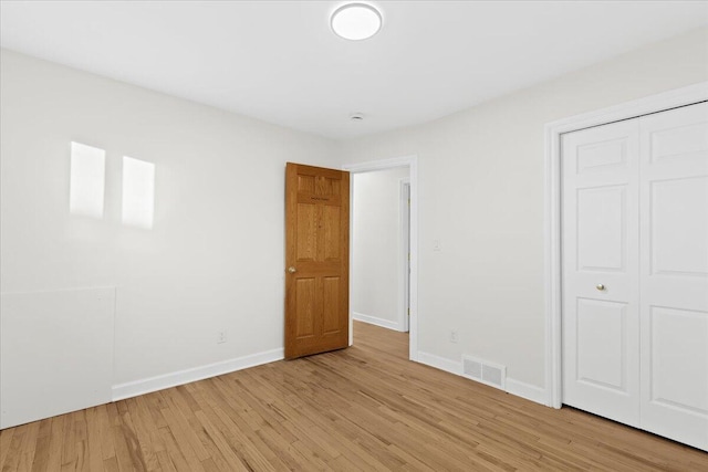 unfurnished bedroom featuring a closet and light wood-type flooring