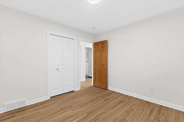 unfurnished bedroom with light hardwood / wood-style flooring and a closet