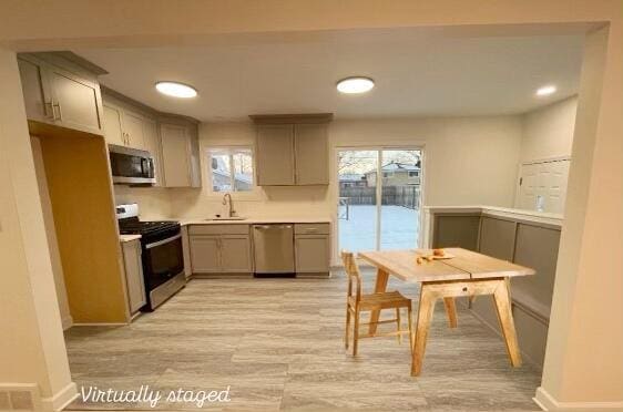 kitchen with gray cabinetry, sink, and appliances with stainless steel finishes