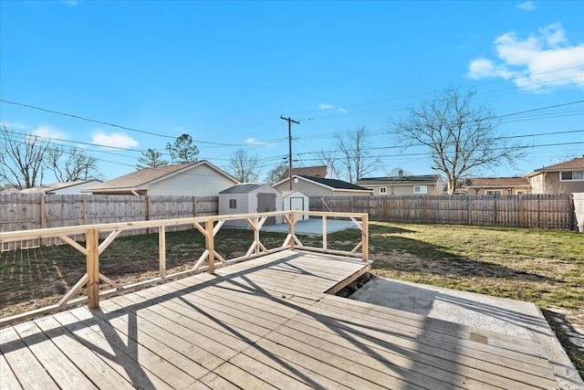 wooden deck with a yard and a storage unit