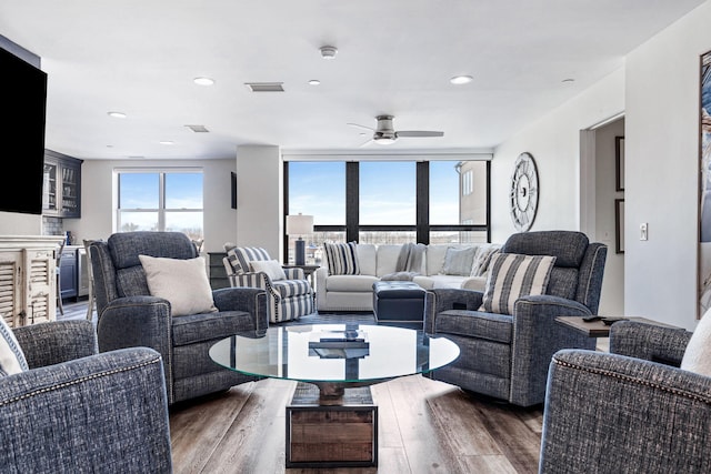 living room featuring dark wood-type flooring, expansive windows, and ceiling fan