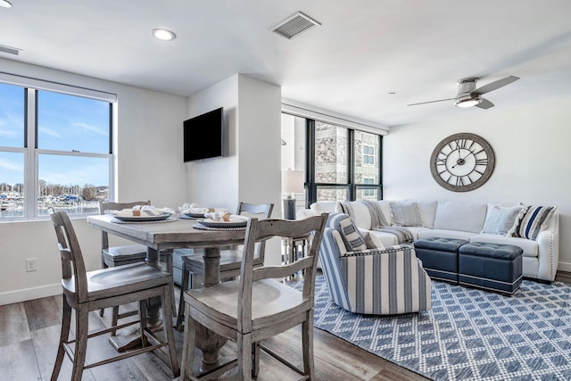 dining space featuring wood-type flooring and ceiling fan