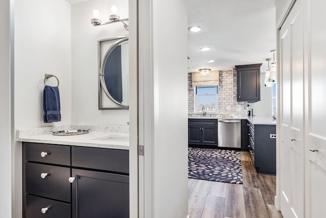 bathroom featuring vanity, decorative backsplash, and wood-type flooring