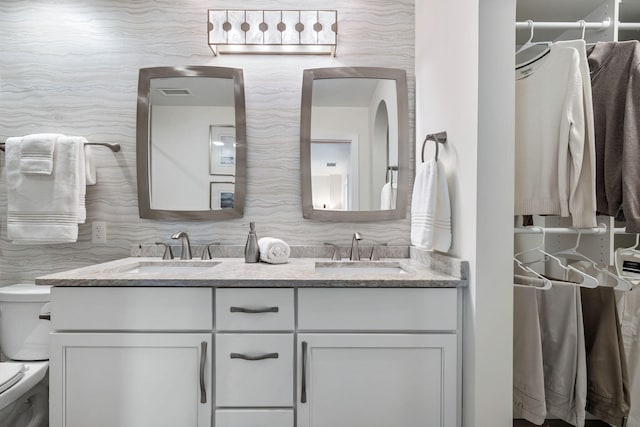 bathroom with vanity, decorative backsplash, and toilet