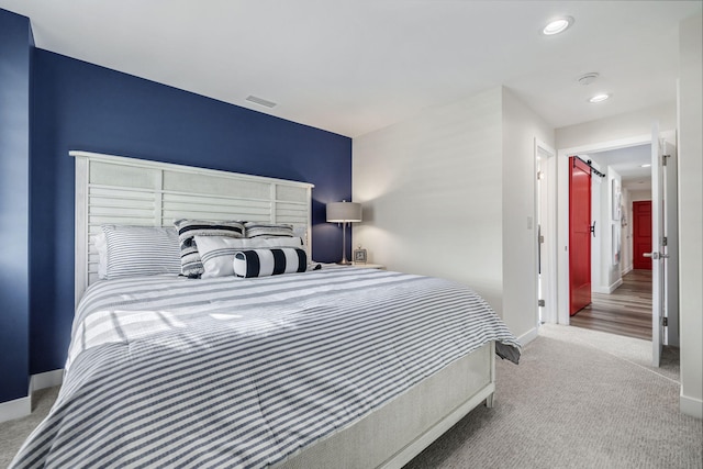 carpeted bedroom featuring a barn door