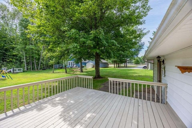 wooden terrace featuring a playground and a yard