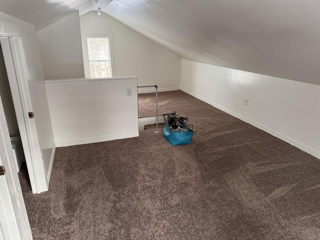 additional living space featuring vaulted ceiling and dark carpet