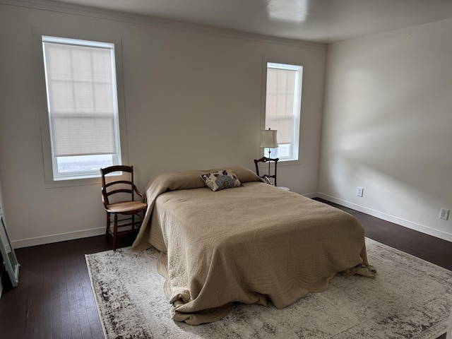 bedroom featuring multiple windows, ornamental molding, and dark wood-type flooring