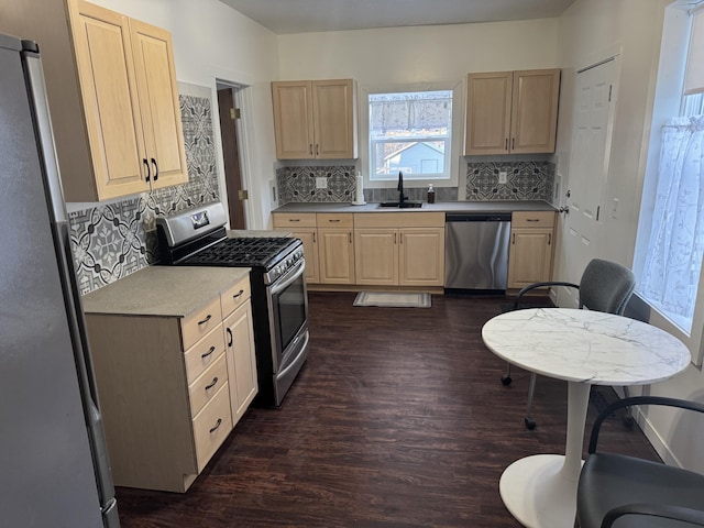 kitchen with light brown cabinetry, sink, backsplash, and stainless steel appliances