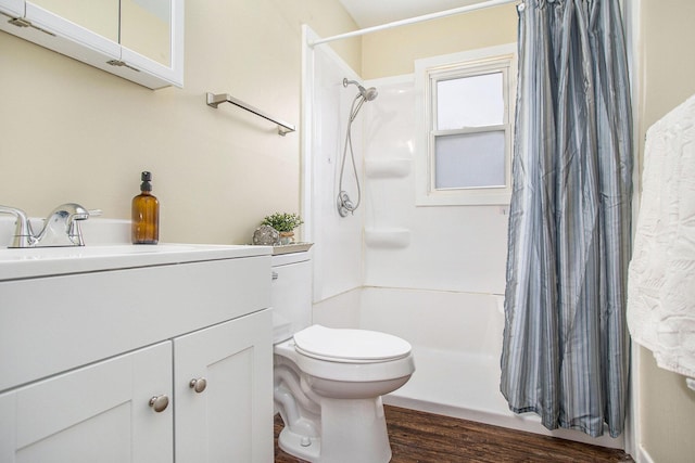 bathroom with hardwood / wood-style floors, toilet, vanity, and a shower with curtain