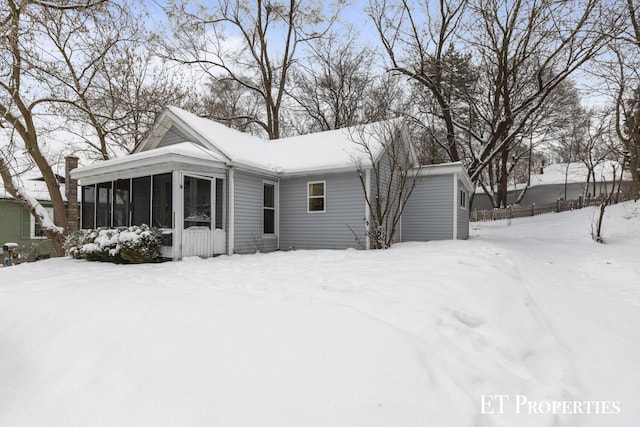 snow covered property featuring a sunroom