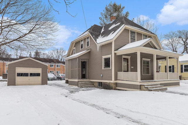 view of front facade featuring covered porch, a garage, and an outbuilding