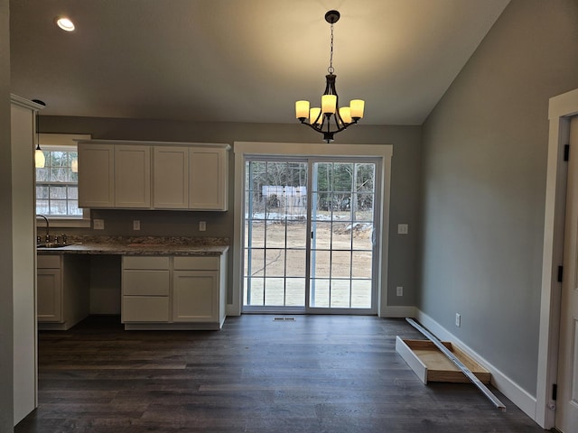 kitchen featuring dark wood-type flooring, a sink, white cabinets, and a healthy amount of sunlight