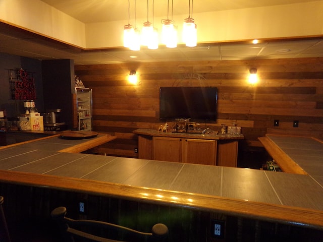 kitchen with pendant lighting and wood walls