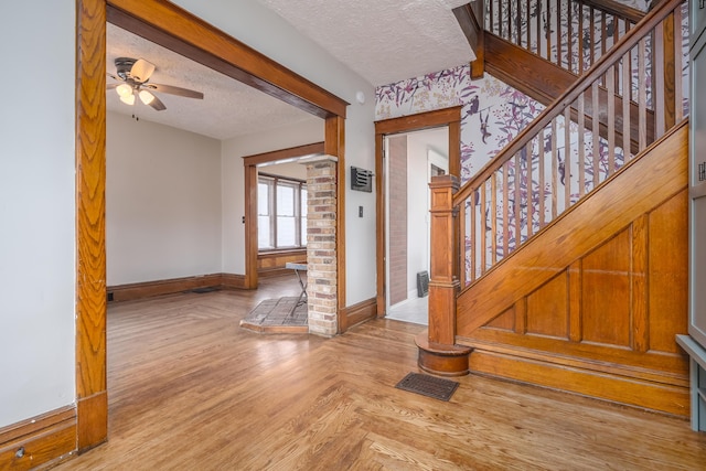 foyer with ceiling fan and a textured ceiling