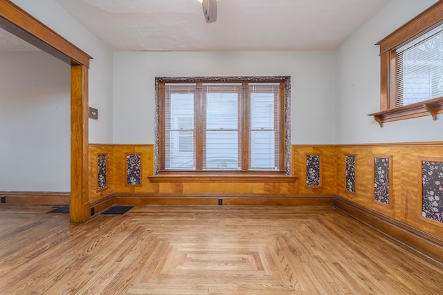 spare room with plenty of natural light and light parquet flooring