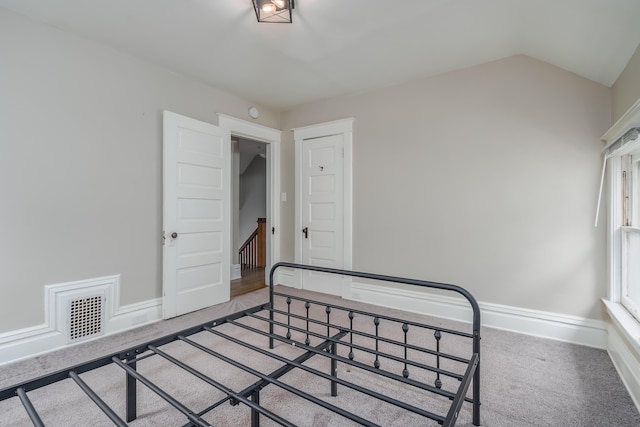 carpeted bedroom with vaulted ceiling