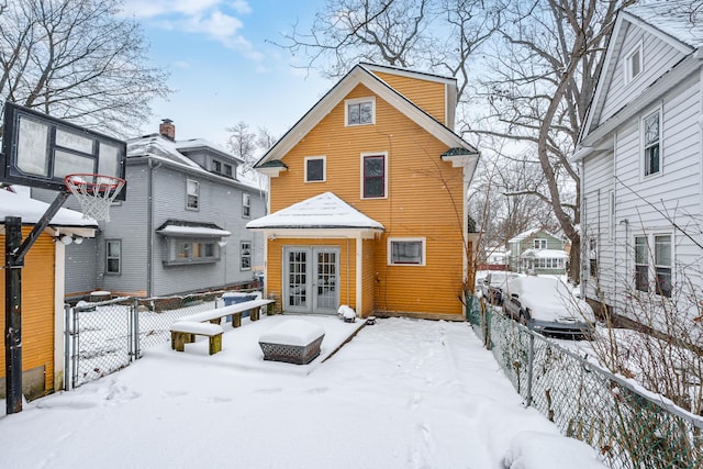 view of snow covered rear of property