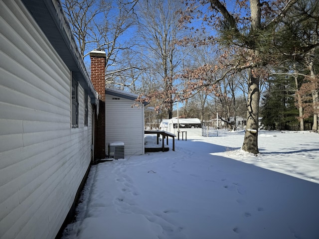 yard covered in snow featuring central AC unit