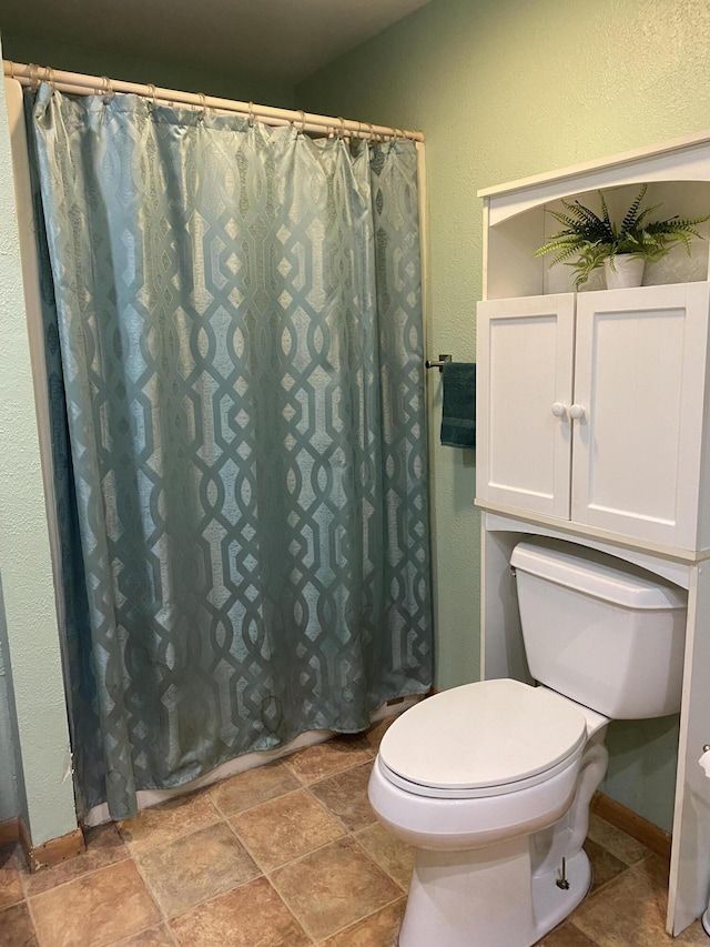 bathroom with toilet and a shower with curtain