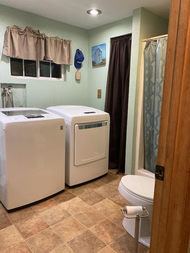 bathroom with washer and dryer, toilet, and a shower with curtain